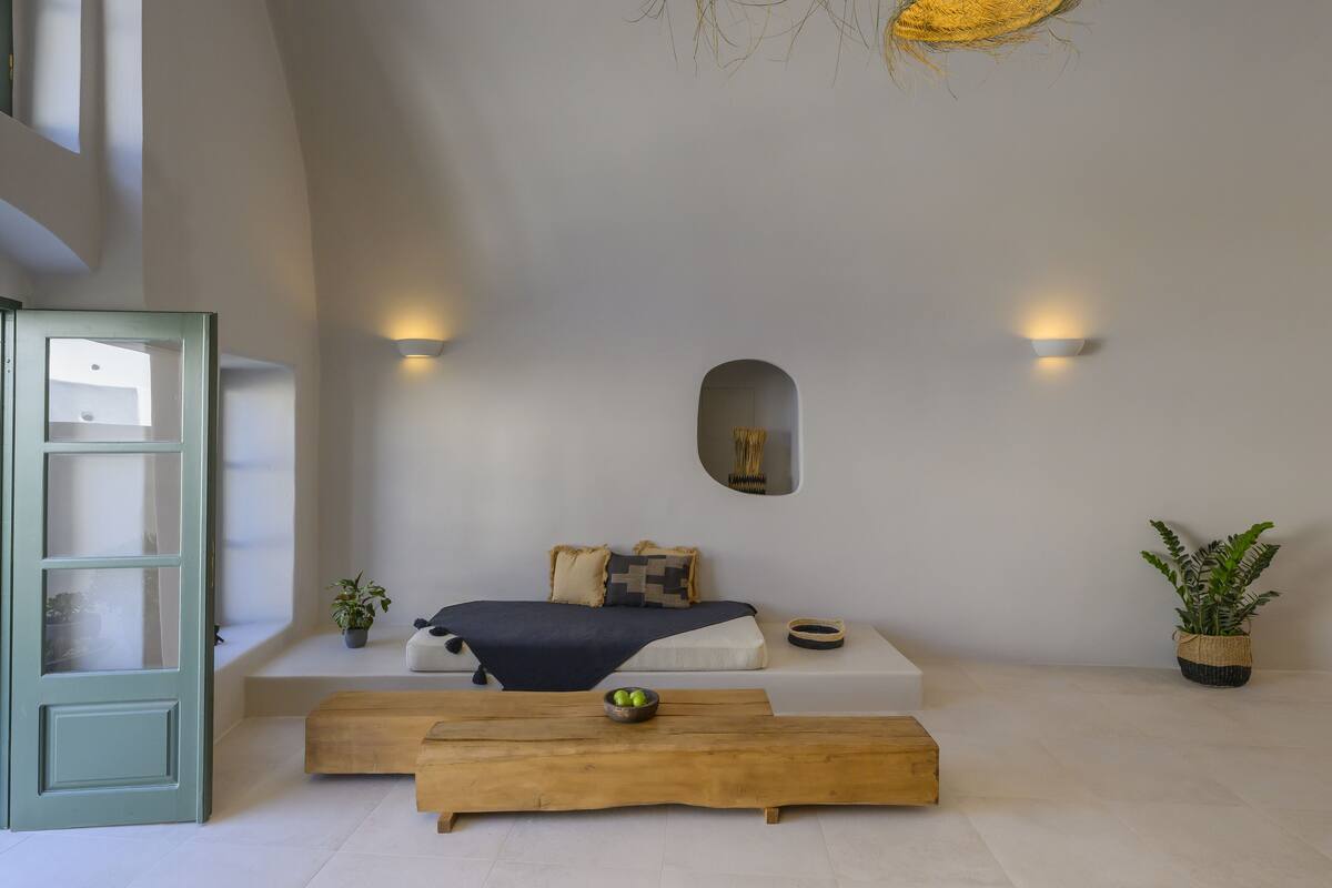 Un dormitorio minimalista con cama, mesita de noche y un amplio ventanal.