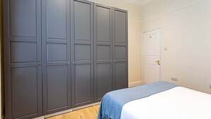 A bedroom with a bed, a wardrobe, and a door.