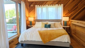 A bedroom with a large bed, two bedside tables with lamps, a window with curtains, and a view of greenery outside. - A Romantic Getaway on the Bourbon Trail (Willisburg)