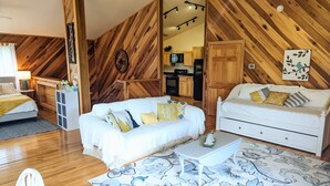 A cozy room with a bed, two sofas, a coffee table, and a patterned rug. - A Romantic Getaway on the Bourbon Trail (Willisburg)