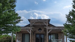 A rustic building with a wooden roof, brick walls, and large windows. - A Romantic Getaway on the Bourbon Trail (Willisburg)