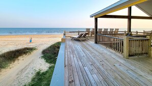 A wooden deck with lounge chairs overlooking a beach. - Beachfront Retreat l Hot Tub l Gulf Views, Wraparound Deck, Sleeps 12, Pet-Friendly, & More (Gilchrist)