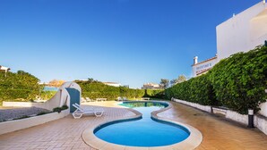 A swimming pool with lounge chairs, a small water slide, and a restaurant named 'Tavertino's' in the background.