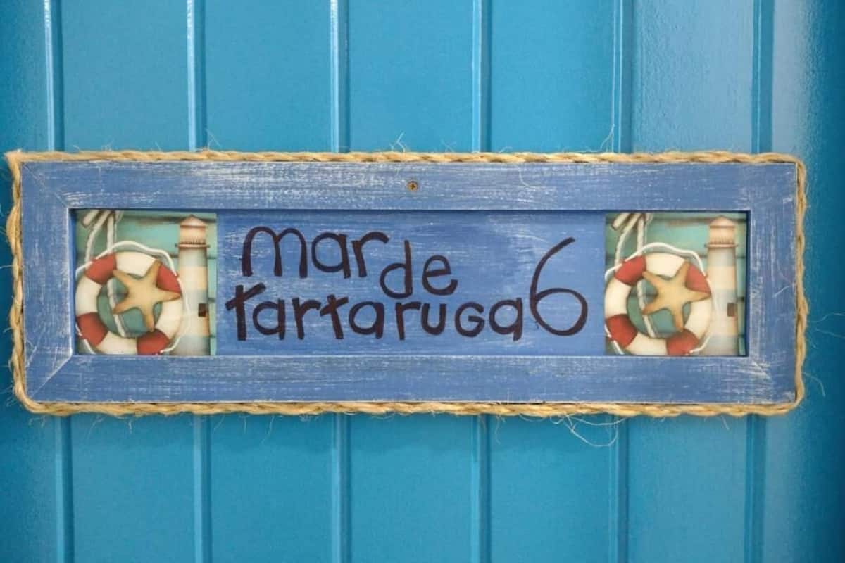 A blue door with a sign that reads "marde tarugab6" and two life rings.