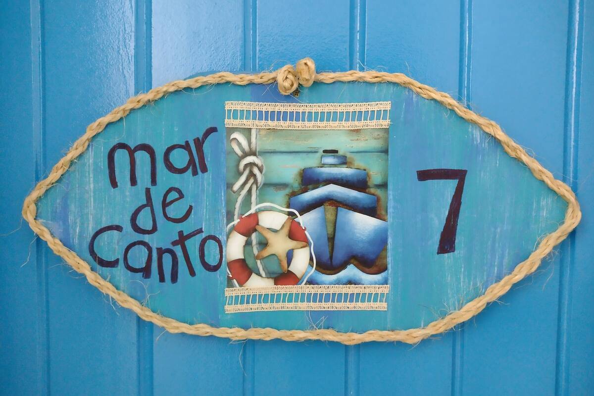 A blue sign with the text "mar de canto" and the number 7, surrounded by nautical decorations.