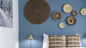A bedroom with a bed, a nightstand, a lamp, and wall decor. - Kettle Valley Beach Resort (Penticton)