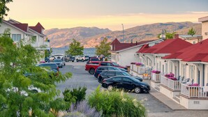 A coastal street with parked cars, houses with red roofs, and a view of mountains in the background. - Kettle Valley Beach Resort (Penticton)