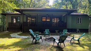 Une cabane dotée d’un patio couvert, de meubles d’extérieur et d’un foyer.