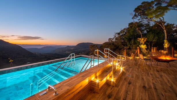 A wooden deck with a pool and outdoor seating, overlooking a mountainous landscape. - Château Laghetto Collection (Gramado)