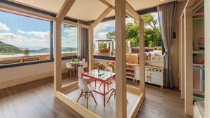 A spacious room with a large window offering a scenic view of hills and a lake. - Château Laghetto Collection (Gramado)