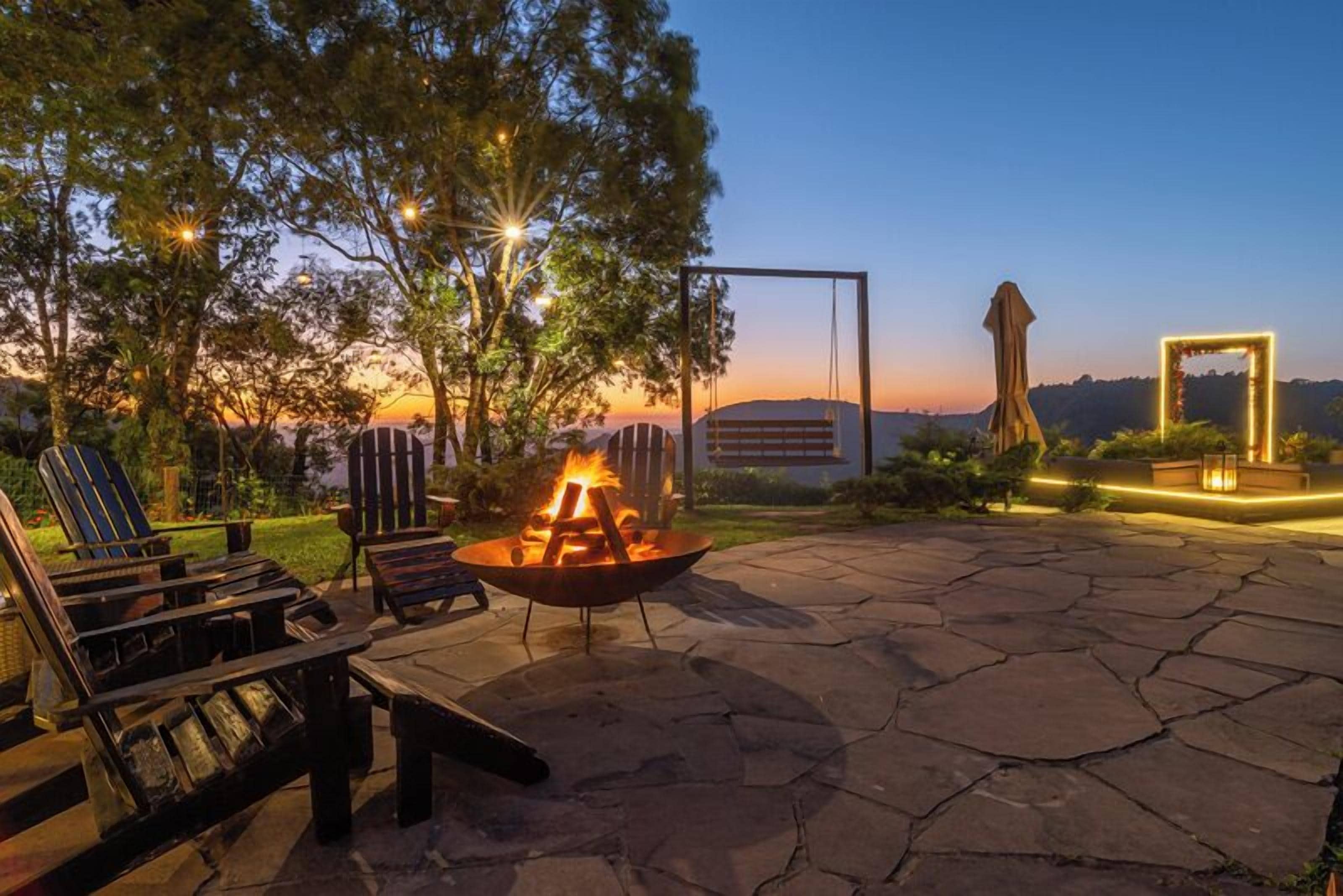 Un patio al aire libre con un pozo de fuego, sillones de descanso y un sendero de piedra.
