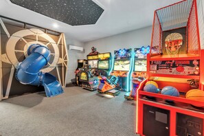A children's play area with a slide, arcade games, and basketball hoops.