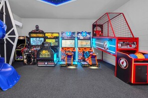A gaming arcade with various machines, including 'Terminator' and 'Sno Cross' games, and a basketball shooting game.