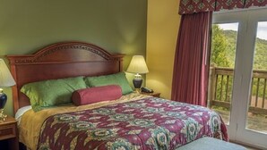 A bedroom with a large bed, two bedside tables with lamps, a bench, and a balcony with a view of greenery. - 4th of July Week 2024 Massanutten Resort, 2BDRM 2BA Sleeps 6 (Massanutten)