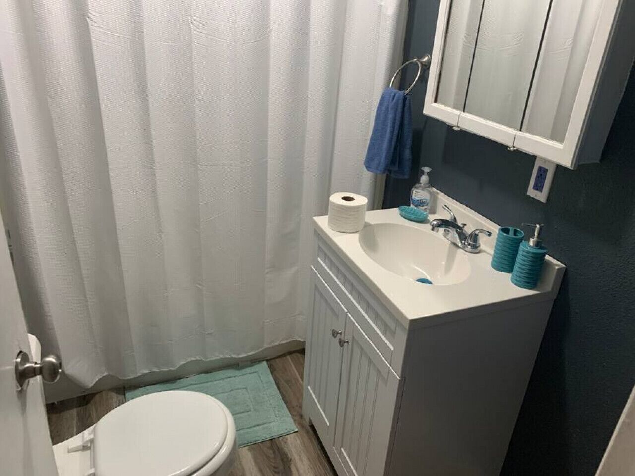 Een kleine badkamer met toilet, wastafel en spiegel.