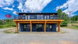 A two-story building with a balcony, a flag, and a covered outdoor area. - Lakeside Bungalows Unit 1&2 (Bayview)