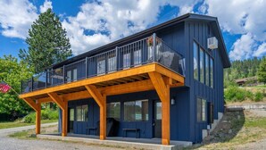 A modern two-story house with a wooden deck and large windows. - Lakeside Bungalows Unit 1&2 (Bayview)