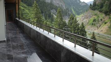 A corridor with a view of a river and mountains.