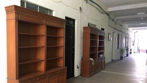 A hallway with large wooden shelving units and a tiled floor. - HOTEL HOSTAL CASA DEL ABOGADO (Córdoba)