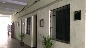 A hallway with large windows, potted plants, and a tiled floor. - HOTEL HOSTAL CASA DEL ABOGADO (Córdoba)
