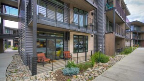 A modern multi-story building with balconies, large windows, and a stone pathway leading to the entrance. - River West · Upscale Value, Centrally Located & Comfortable (Silverthorne)