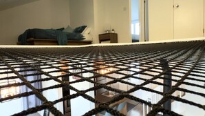 Una sala de estar moderna con un sofá, un comedor con sillas y una cocina al fondo.