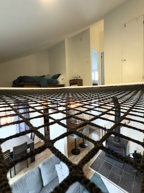 Een moderne woonkamer met een bank, een eethoek met stoelen en een keuken op de achtergrond.