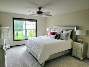 Enjoy a restful stay in this cozy room with a neatly made bed, bedside table, and window offering a view of the outdoors.
