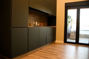 Une cuisine moderne avec des meubles de couleur sombre et un plan de travail en bois.