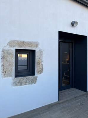 Un bâtiment moderne avec une fenêtre en pierre et une porte sombre.