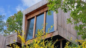 A modern building with large windows and wooden exterior. - Loch Awe Luxury Eco Cabins (Dalmally)