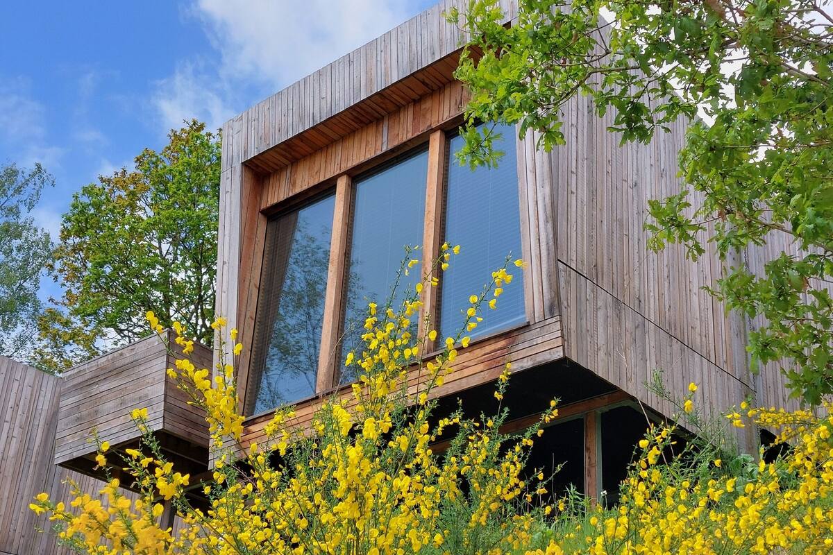 A modern building with large windows and wooden exterior.