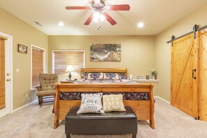 A bedroom with a bed, a chair, a desk, a ceiling fan, and a wooden wardrobe. - V1211-1, Golf-themed 2Br, 2Ba Villa on the 13th Fairway (Branson West)