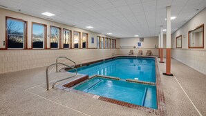 A large indoor swimming pool with clear blue water, surrounded by tiled walls and a tiled floor. - Lidos Lodge (Lincoln)