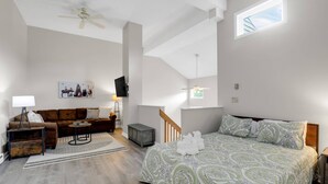 A spacious living area with a sofa, coffee table, and a bed with a patterned bedspread. - Lidos Lodge (Lincoln)