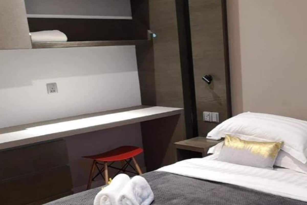 Une chambre d’hôtel avec un lit, un bureau et une chaise.