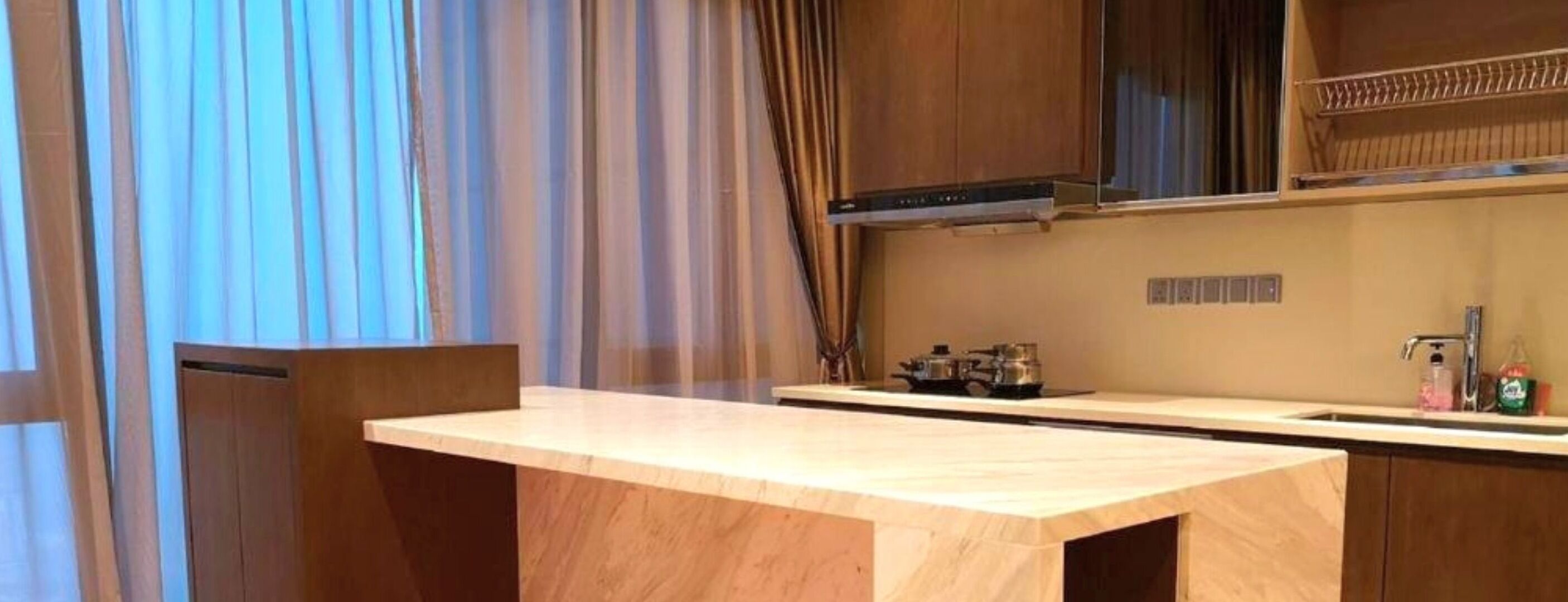 A modern kitchen with a wooden countertop, a stove, and a sink.