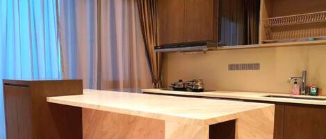 A modern kitchen with a wooden countertop, a stove, and a sink.