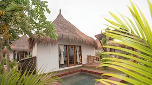 A house with a thatched roof, a swimming pool, and a garden with tropical plants. - AMALIFE Beach Club & Hotel  (Cartagena)