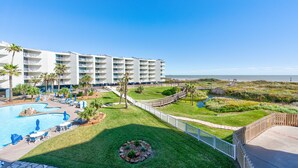 Een resort met een zwembad, ligbedden en uitzicht op de oceaan.