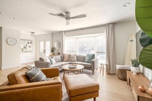 Un salon avec un canapé, une table basse et un ventilateur de plafond.