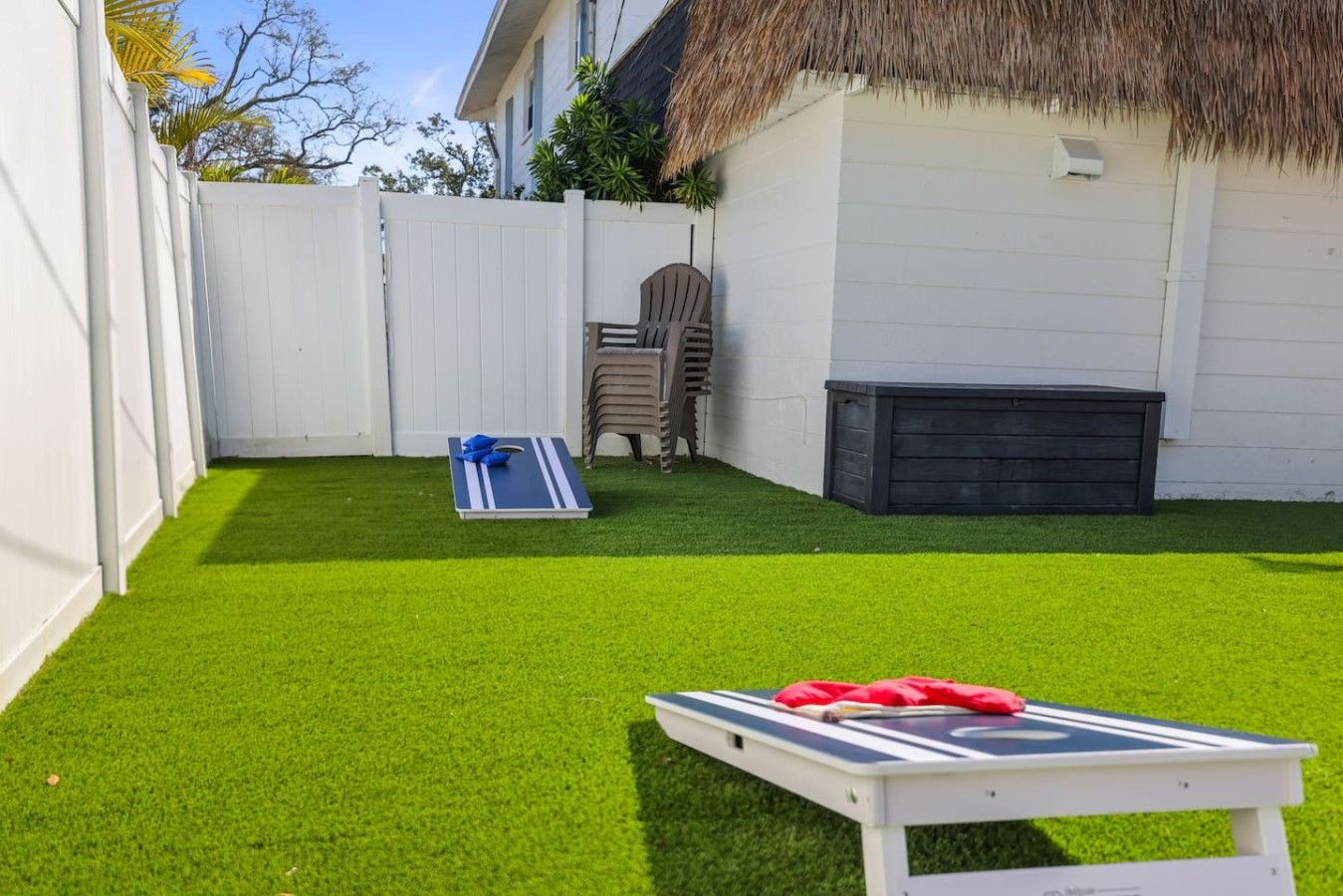 A backyard with artificial grass, a pool table, and a barbecue grill.