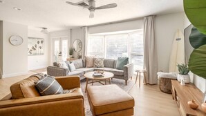 A living room with a sofa, coffee table, and a ceiling fan.