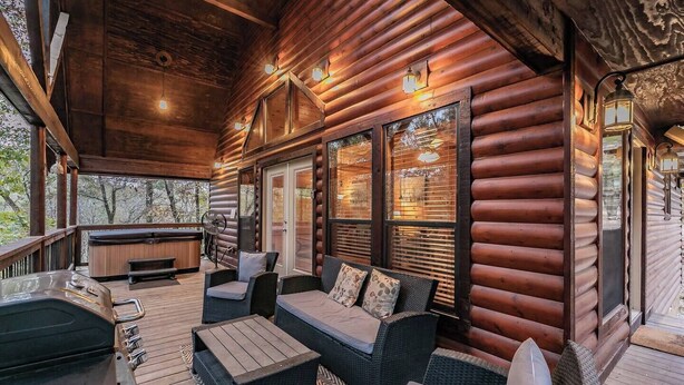 A log cabin with a covered porch, outdoor seating area, and a hot tub. - Secluded Cabin w/ Hot Tub Near State Park (Broken Bow)