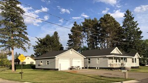 A two-story house with a garage, a porch, and a lawn.