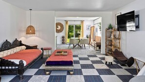 A modern living room with a checkered floor, a sofa, a coffee table, and a TV mounted on the wall. - Little Green House
Eclectic Olympic National Park Basecamp, Dogs allowed (Port Angeles)