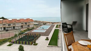 Un balcón con vista a una piscina y una zona residencial.