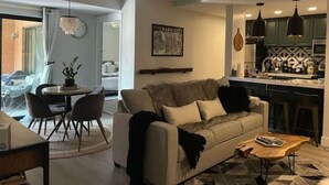 Una sala moderna con sofá, mesa de centro y comedor.