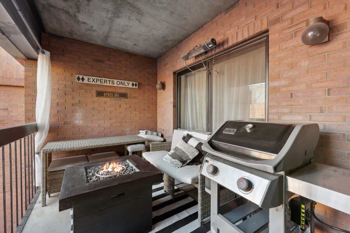 A patio with a grill, a cushioned seating area, and a sign indicating 'Experts Only.'