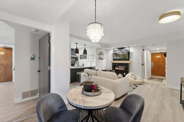 A modern living room with a marble coffee table, a sofa, and a fireplace.